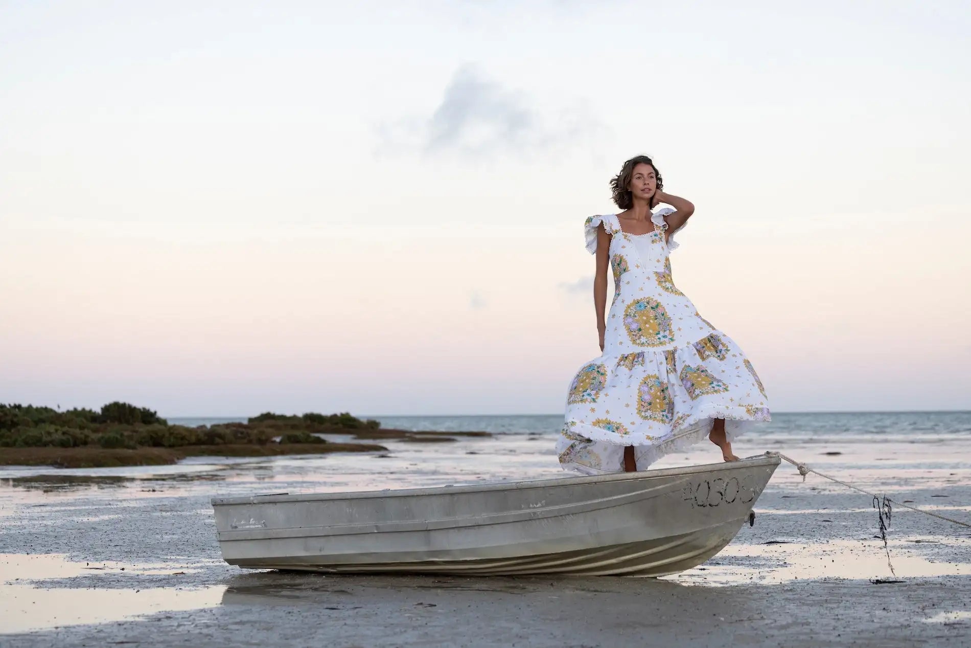 White floral print summer dress with ruffled hem and lace-up back.