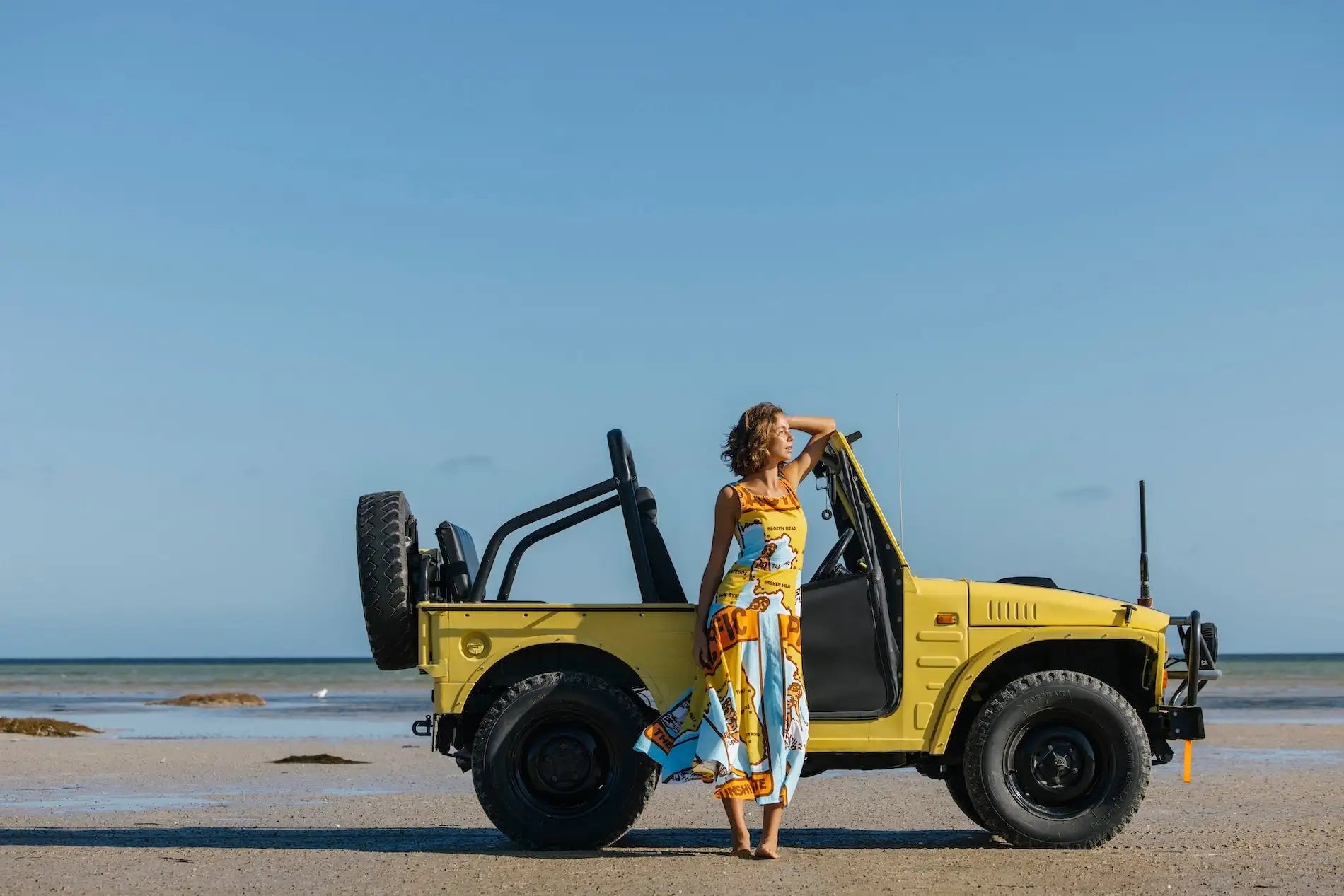 Yellow vintage-style off-road vehicle with black tires and roll bars
